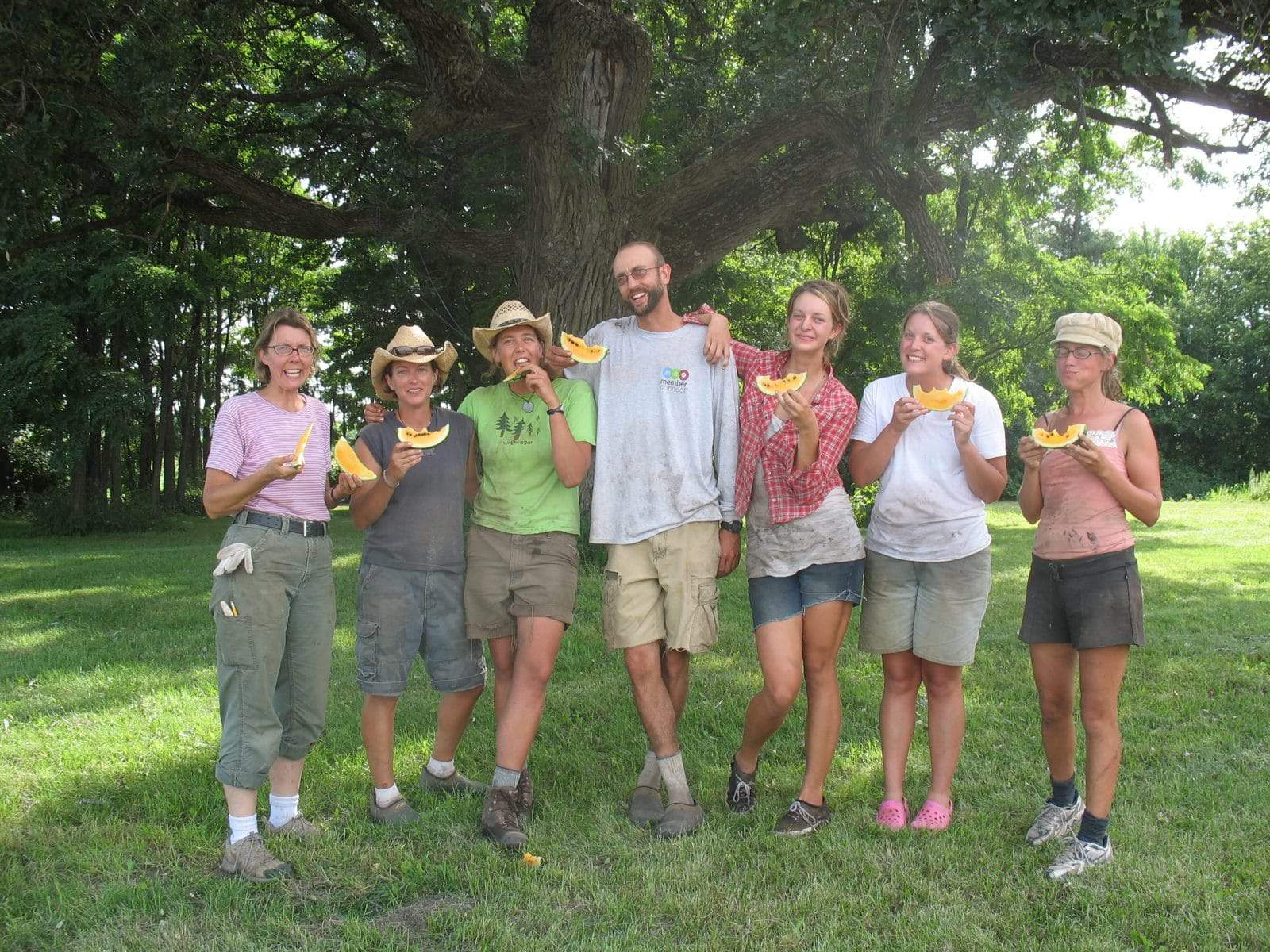 The farm crew at the Wedge owned and operated Gardens of Eagan eat watermelon under The Oak.